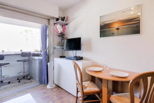 une petite salle à manger avec une table et une télévision dans l'établissement Le Studio du Mail, à Six-Fours-les-Plages