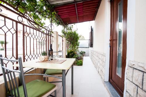 an outdoor patio with a table and chairs on a balcony at Apartments Aria in Zadar