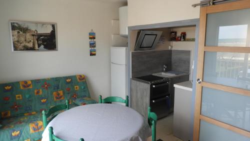 une petite cuisine avec une table et un évier dans l'établissement Appartement Saint Pierre 30m de la plage, à Saint Pierre La Mer