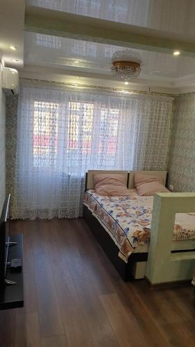 ゲレンジークにあるApartment on Khersonskaya streetの窓付きの部屋にベッド付きのベッドルーム1室があります。