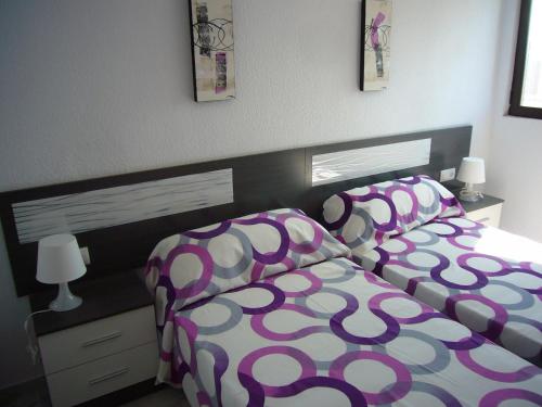 ベニドルムにあるResidencial Paraiso - Fincas Arenaのベッドルーム1室(紫と白の掛け布団付きのベッド1台付)
