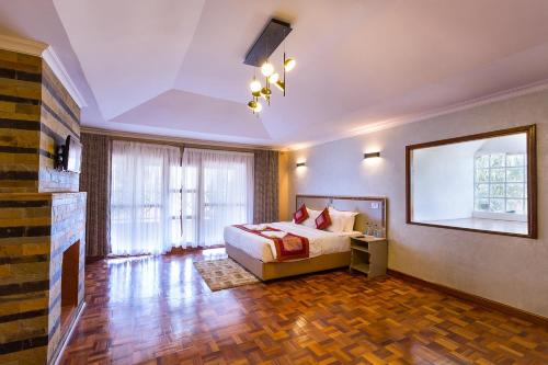 a bedroom with a bed and a large window at Comfort Gardens Sweetwaters in Nanyuki