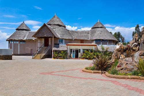 a large building with a thatched roof at Comfort Gardens Sweetwaters in Nanyuki