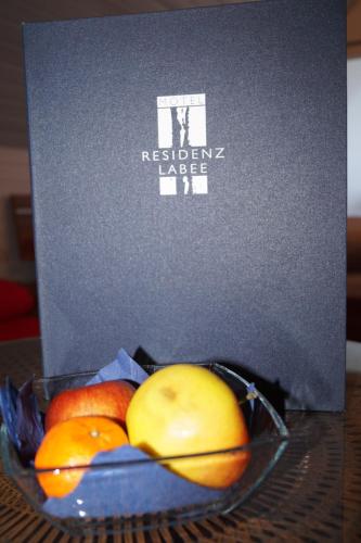 a bowl of fruit in front of a box at Residenz Labee in Weil am Rhein