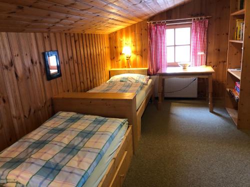 a room with two beds and a desk and a window at Waldklause in Schönau am Königssee