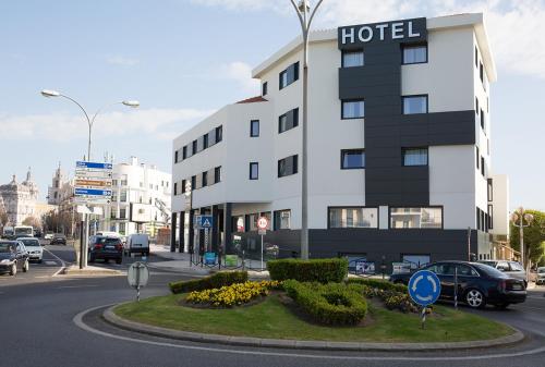 un edificio de hotel en una calle de la ciudad con coches aparcados en Mafra Hotel, en Mafra