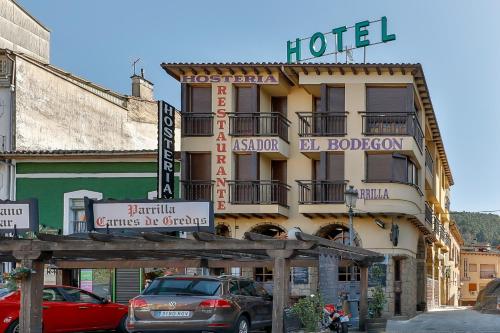 a hotel building with cars parked in front of it at Hostería El Bodegón De Gredos in Arenas de San Pedro
