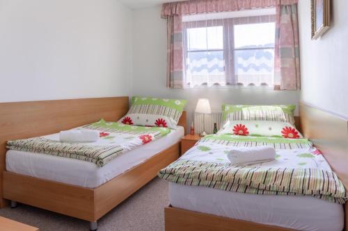 a bedroom with two beds and a window at Apartmany Aneta in Špindlerův Mlýn