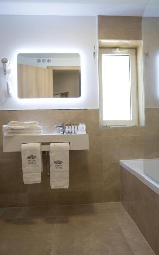 a bathroom with a sink and a mirror at Mafra Hotel in Mafra