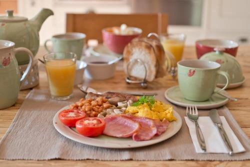 a plate of breakfast food on a wooden table at The Larches Ledbury in Ledbury