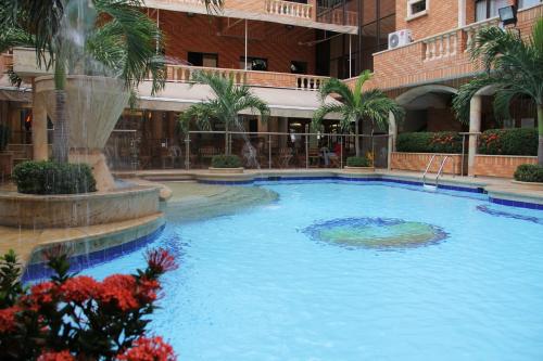 a large swimming pool in a building with a fountain at Hotel Tativan in Valledupar