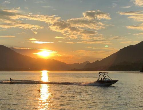 a boat in the water with the sun setting at Ferienwohnungen Sammer in Strobl