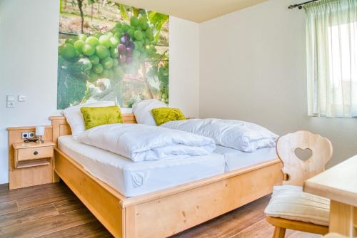Bett in einem Zimmer mit Wandgemälde in der Unterkunft Gästehaus Weingut Politschek in Bad Friedrichshall
