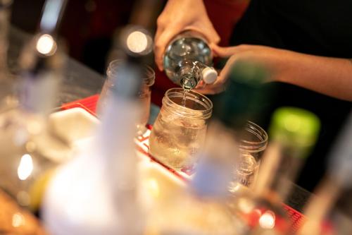 a person is pouring wine into a glass at Hotel Isolabella Wellness in Fiera di Primiero