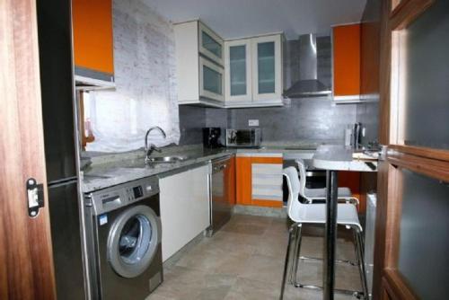 a kitchen with a washing machine and a washer at Casa Rural El Torreón II in Caleruega