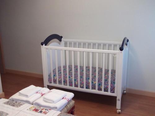 - un lit bébé blanc avec 2 serviettes blanches dans l'établissement Casa Rural El Torreón II, à Caleruega