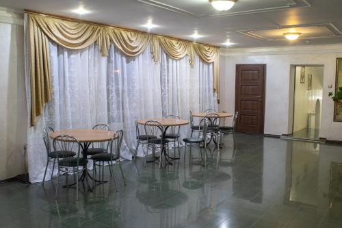 a group of tables and chairs in a room with curtains at Britaniya in Kharkiv
