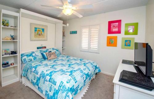 Schlafzimmer mit einem Bett und einem Deckenventilator in der Unterkunft Ocean Life Beach Condo - Only Steps to the Beach in Saint Augustine Beach