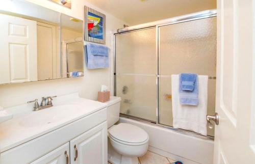 ein Bad mit einer Dusche, einem WC und einem Waschbecken in der Unterkunft Ocean Life Beach Condo - Only Steps to the Beach in Saint Augustine Beach