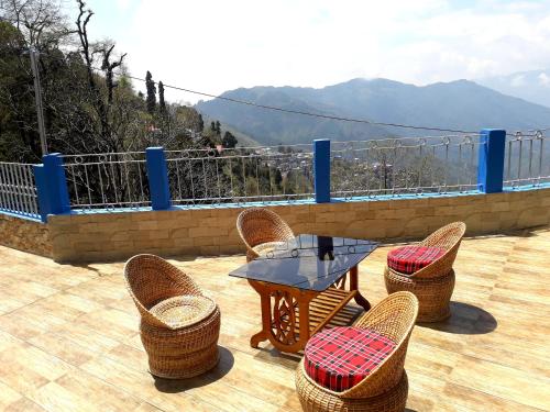 d'un patio avec des chaises en osier et une table sur une terrasse. dans l'établissement FRATERNITY HOMESTAY, à Darjeeling
