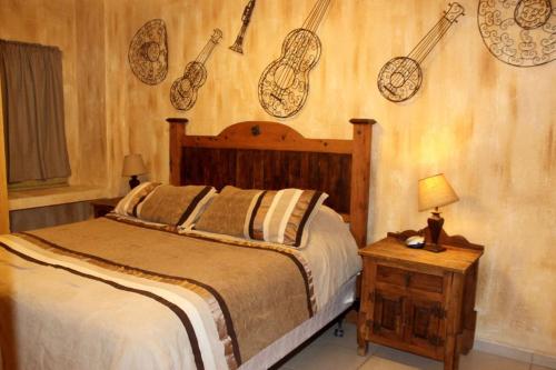 a bedroom with a bed with musical instruments on the wall at Sonoran Sun 1BR Upper SW 511 by Casago in Puerto Peñasco