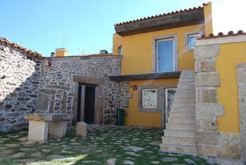 a house with yellow walls and stairs in a yard at Curral de l Tiu Pino in Sendim