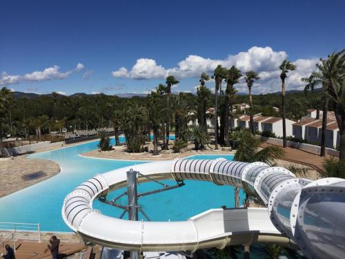 eine Wasserrutsche in einem Pool in einem Resort in der Unterkunft Residence La Palmeraie in Fréjus