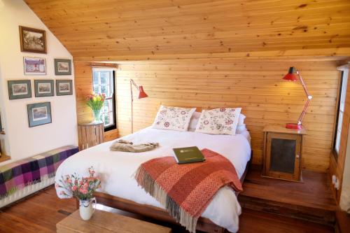a bedroom with a bed in a log cabin at Kiln Wing, Old Corn Mill in Bushmills