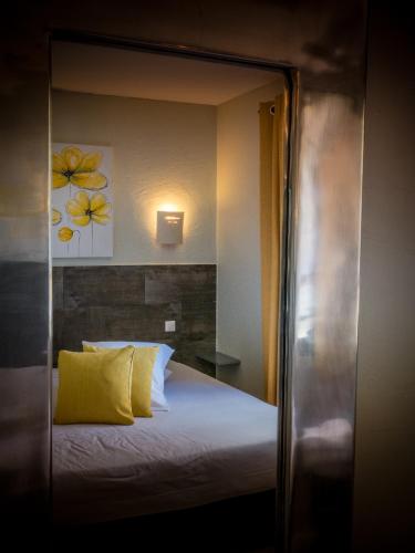 a bedroom with a bed with a yellow pillow at Le Belvedere in Vallon-Pont-dʼArc