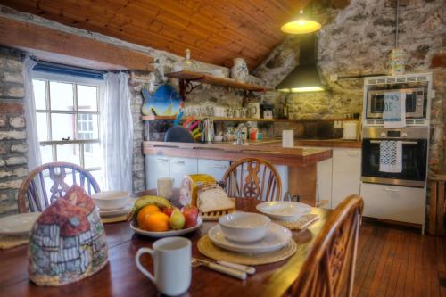 a kitchen with a wooden table with fruit on it at Kiln Wing, Old Corn Mill in Bushmills