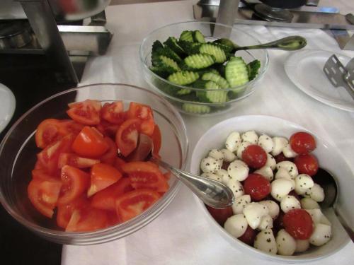 three bowls of tomatoes and other vegetables on a counter at Hotel Roberts in Sibiu