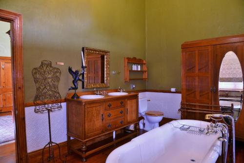 a bathroom with a tub and a sink and a toilet at Die Kliphuis in Standerton