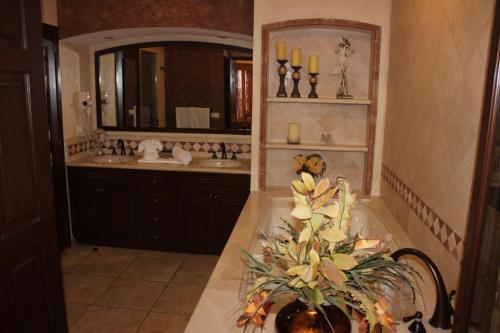a bathroom with a sink and a tub with a vase of flowers at Sonoran Sky 3BR Upper Jacuzzi SKY 702-V by Casago in Puerto Peñasco