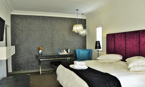 a hotel room with a bed and a desk at Die Kliphuis in Standerton