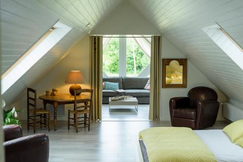 a attic room with a couch and a table at Villa Marine in Plouguin