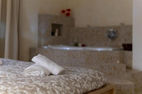 ein Badezimmer mit einer Badewanne und zwei Handtüchern auf einem Bett in der Unterkunft Guarda Che Luna in Sasso di Castalda