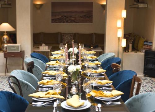 a long table in a room with blue chairs at Dar Mayshad Riad - Luxurious Boutique Hotel in the Medina in Rabat