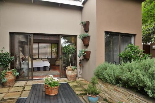 a house with potted plants on a patio at Die Kliphuis in Standerton