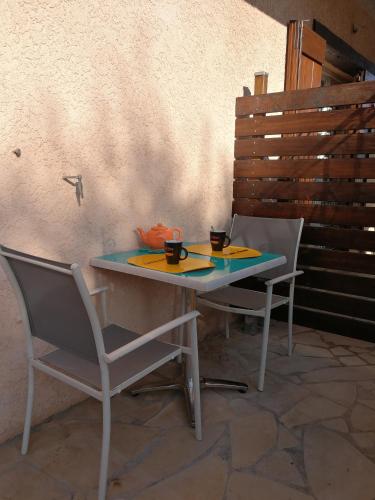 - une table avec deux chaises et deux tasses dans l'établissement Les Charmettes de la Côte - Entre mer et montagne, à Carros