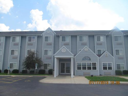 a large gray building with a door in a parking lot at Microtel Inn by Wyndham Champaign in Champaign