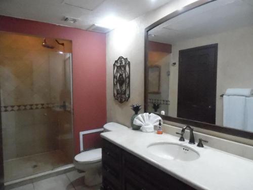 uma casa de banho com um lavatório, um WC e um espelho. em Sonoran Sky 1BR Upper SKY 405-V by Casago em Puerto Peñasco