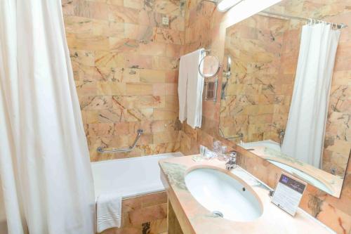 a bathroom with a sink and a shower curtain at Hotel Eurosol Seia Camelo in Seia