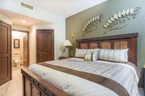 a bedroom with a large bed with a wooden headboard at Sonoran Sky 1BR 1506 by Casago in Puerto Peñasco