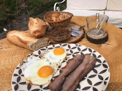 a table with eggs and sausages on a plate at camping l'agrottu au cœur de la corse restaurant creperie in Santa-Lucia-di-Mercurio