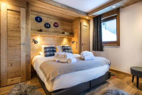 クールシュヴェルにあるKeystone Lodge by Alpine Residencesのベッドルーム1室(大型ベッド1台、タオル付)