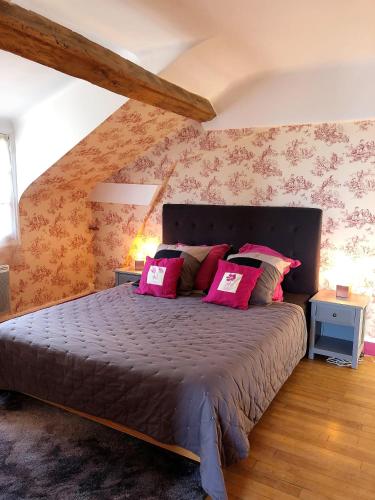 une chambre avec un grand lit avec des oreillers roses dans l'établissement Au Bonheur Dupré B&B, à Montoire-sur-le-Loir