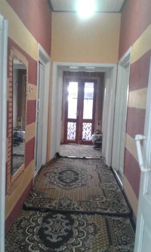 an empty hallway with a door and a rug at Ilgar's Hostel in Sheki