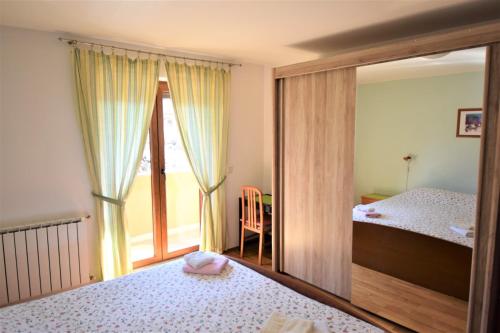 1 dormitorio con 1 cama y ventana con balcón en Apartments Novak, en Rovinj