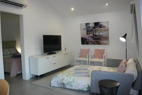 a living room with a bed and a television at APARTAMENTO MAR WITH PARKINg in Sesimbra