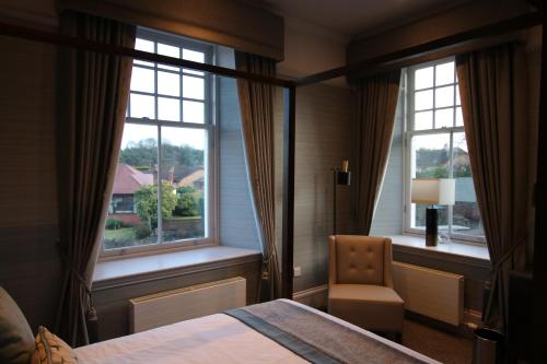 A bed or beds in a room at Castlecary House Hotel